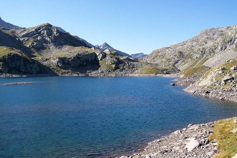 Un des lacs des Sept Laux en été, entouré de pentes rocheuses