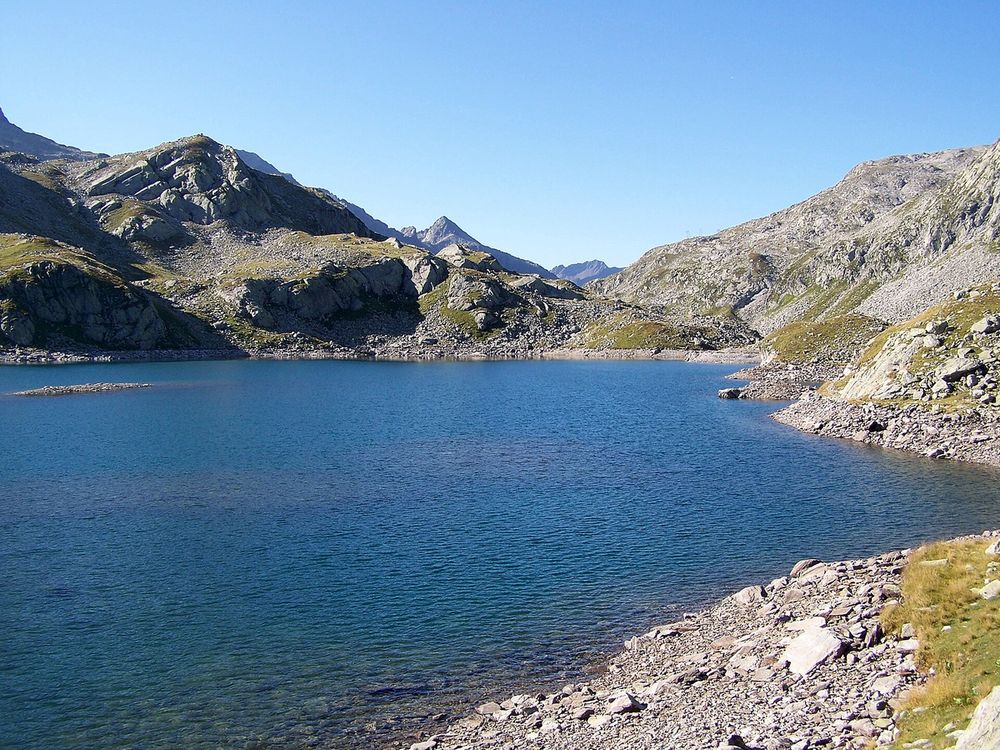 Un des lacs des Sept Laux en été, entouré de pentes rocheuses