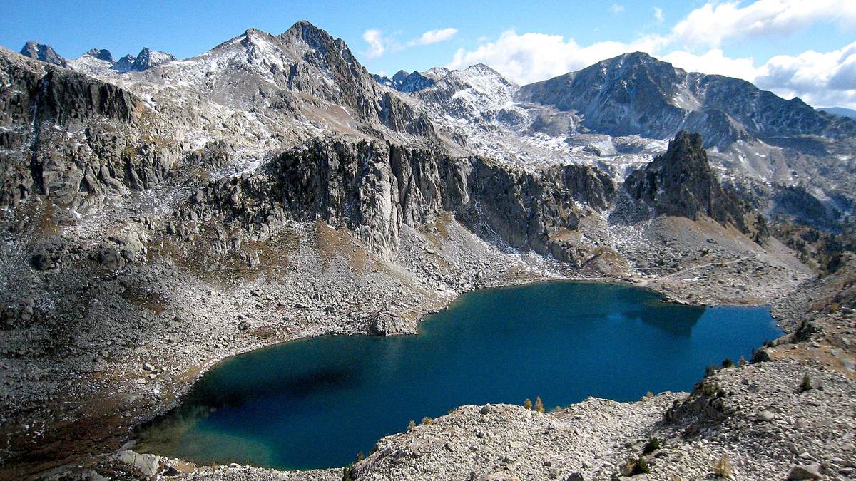 Le lac Nègre, bleu sombre, dans son cirque de granite sous les sommets enneigés