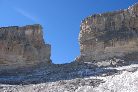 La brèche de Roland, trouée entre deux murailles calcaires, au-dessus d'une pente de pierres saupoudrée de neige