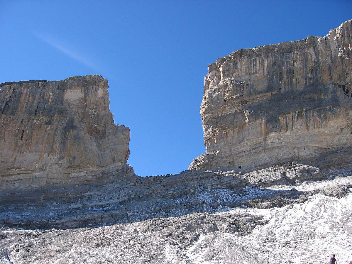 La brèche de Roland, trouée entre deux murailles calcaires, au-dessus d'une pente de pierres saupoudrée de neige