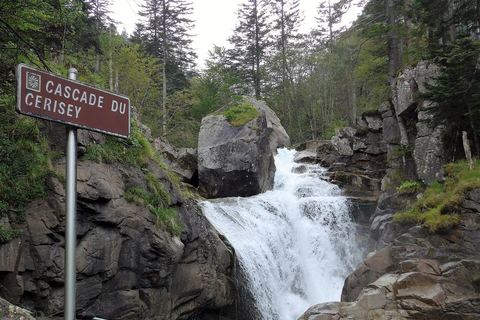 La cascade du Cerisey entre les rochers, avec son panneau